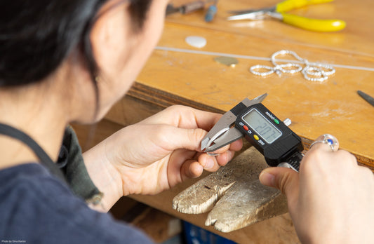 Jewelry Designer Casey Perez sits at her jewelry bench while working on a piece of sustainably made custom jewelry for a client