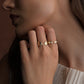 close up lifestyle photo of a model wearing two gold rings.