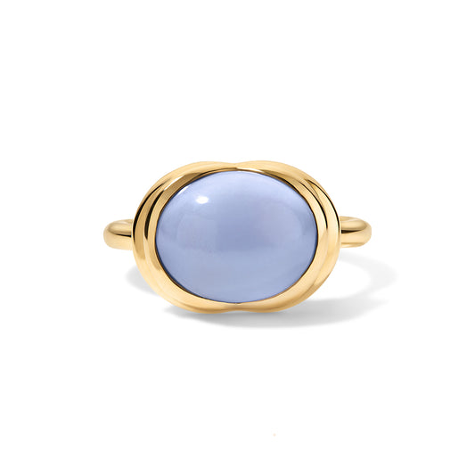 A gold ring featuring a smooth, oval-shaped light blue cabochon gemstone, presented on a clean white background with a soft shadow.